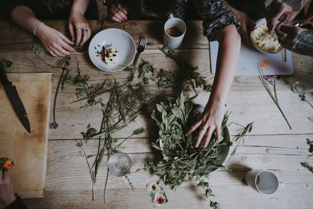 Herbs on a wooden table with hands