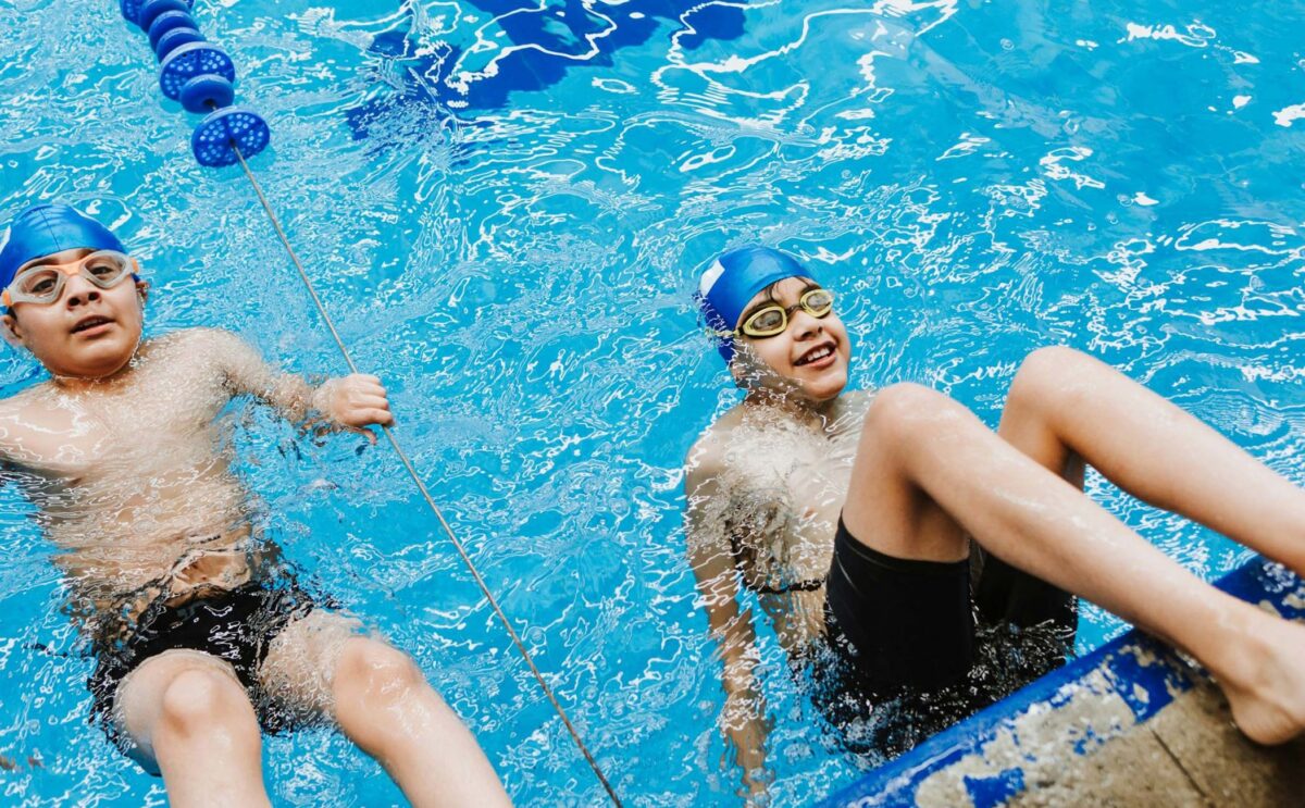 Two boys swimming in the pool with smile