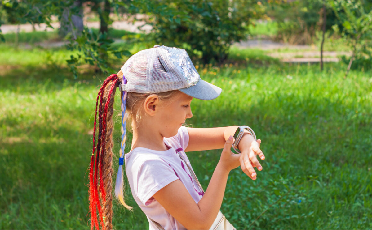 A girl looking at the smartwatch on her wrist outdoor