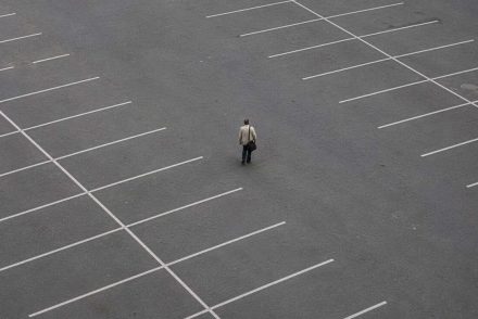 A man standing in the middle of a empty carpark