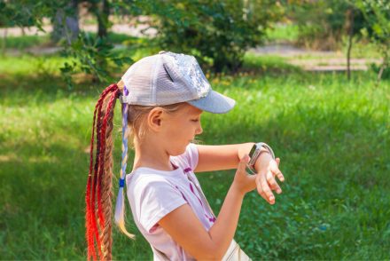 A girl looking at the smartwatch on her wrist outdoor