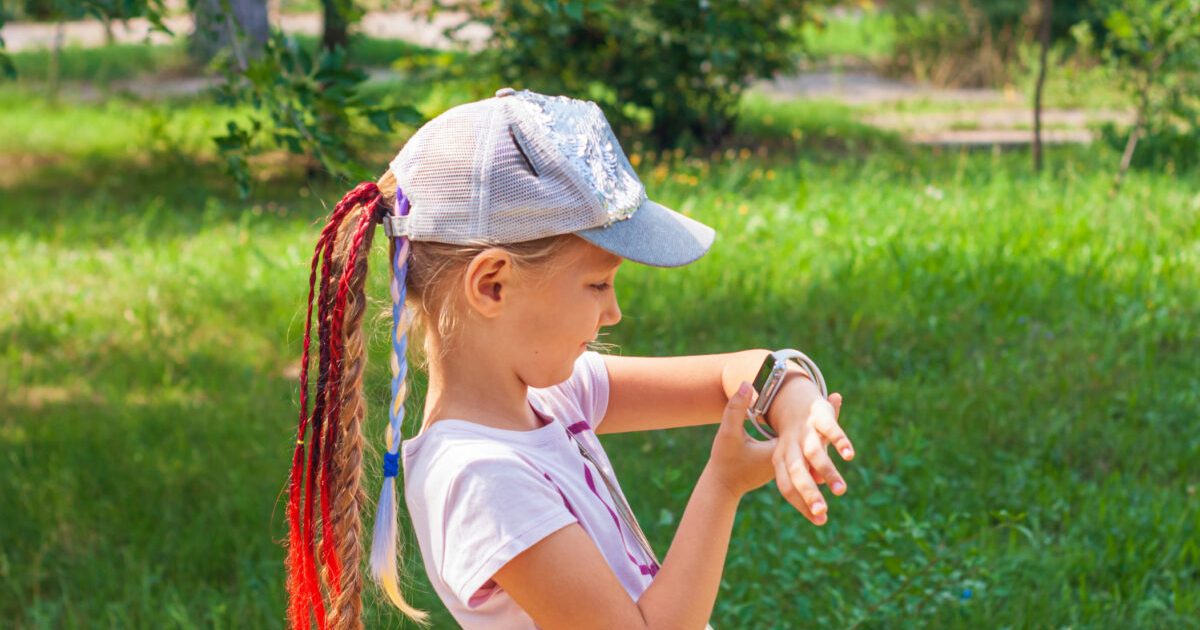 A girl looking at the smartwatch on her wrist outdoor